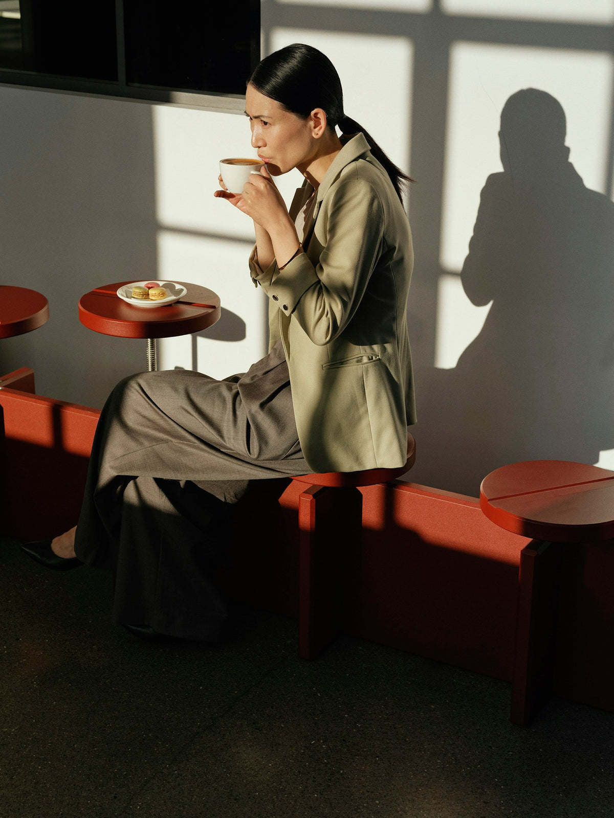 A woman enjoys coffee in a sunlit cafe