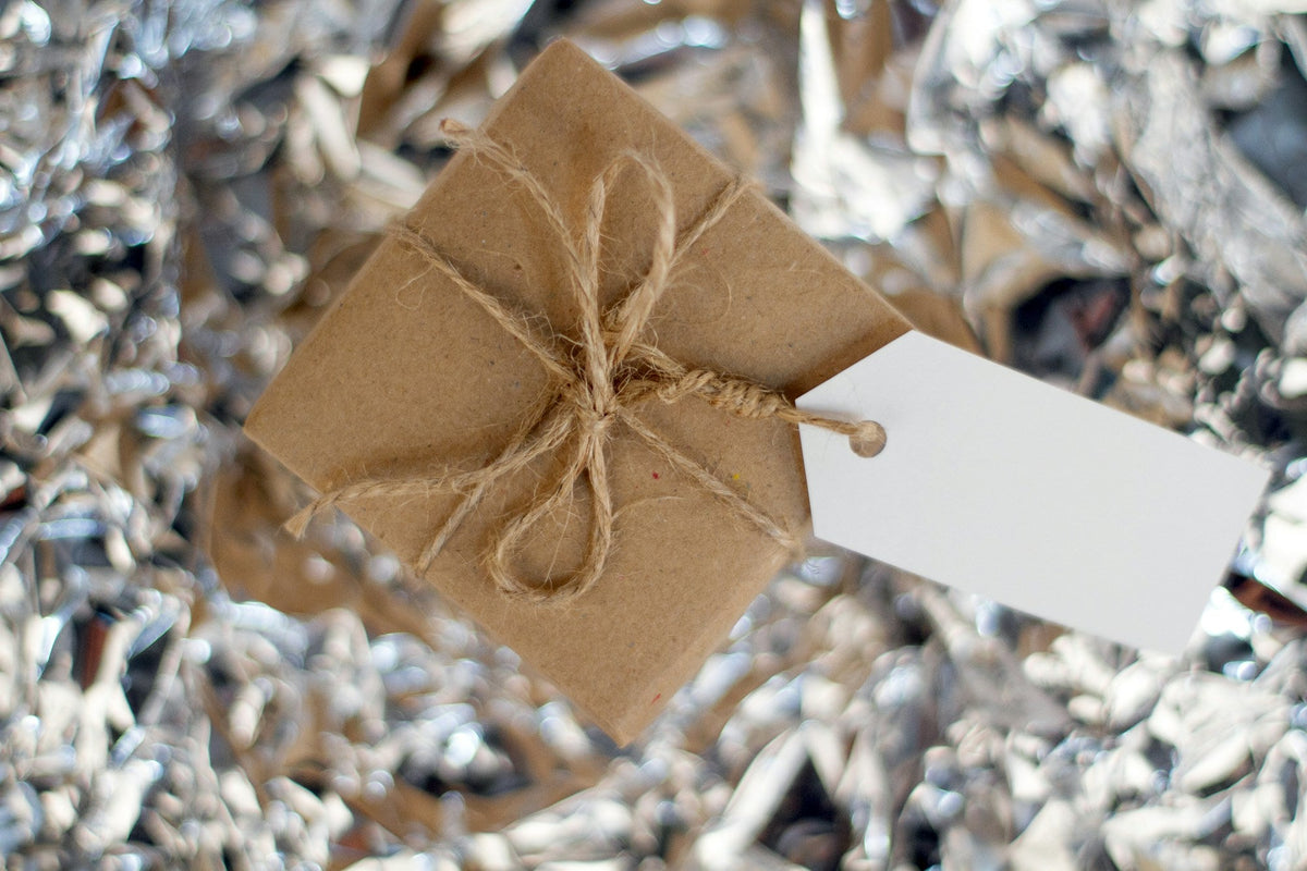 Gift wrapped in warm brown paper and natural string with a white label