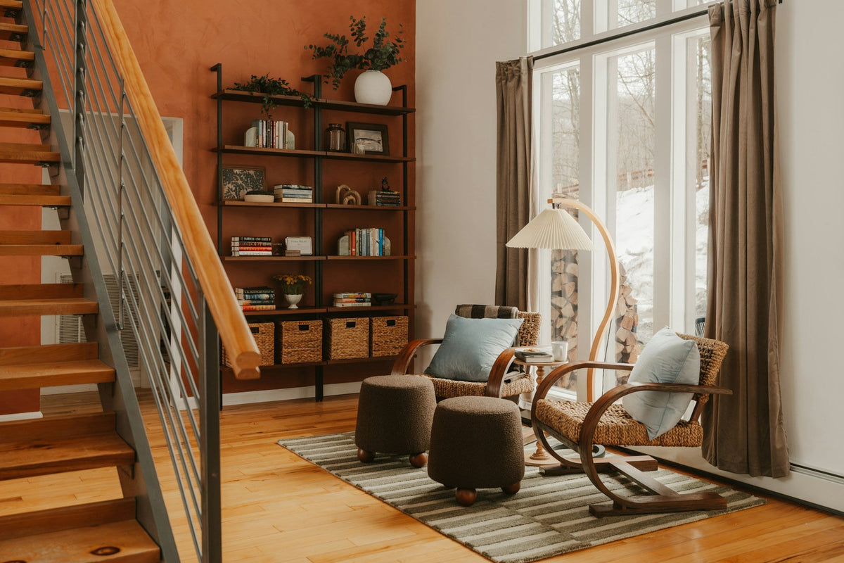 Warm reading nook with wooden chairs, bookshelves and light falling through tall windows